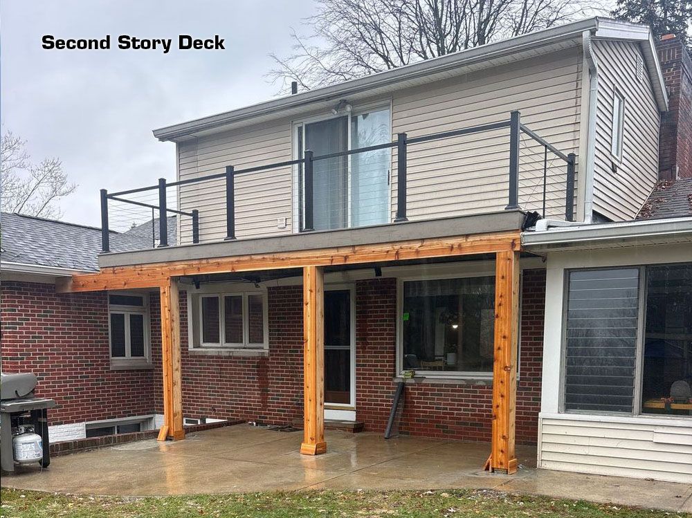 Backyard deck under construction on a two-story house, with orange support posts and brick walls.
