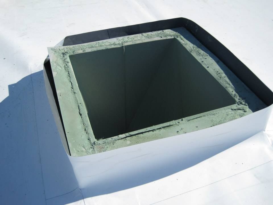 Square rooftop vent with white and black flashing.