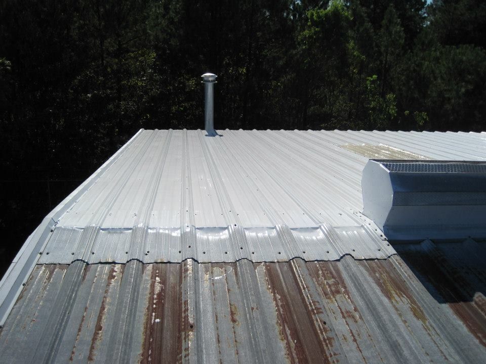 Metal roof with a section showing rust, painted white on top, chimney.