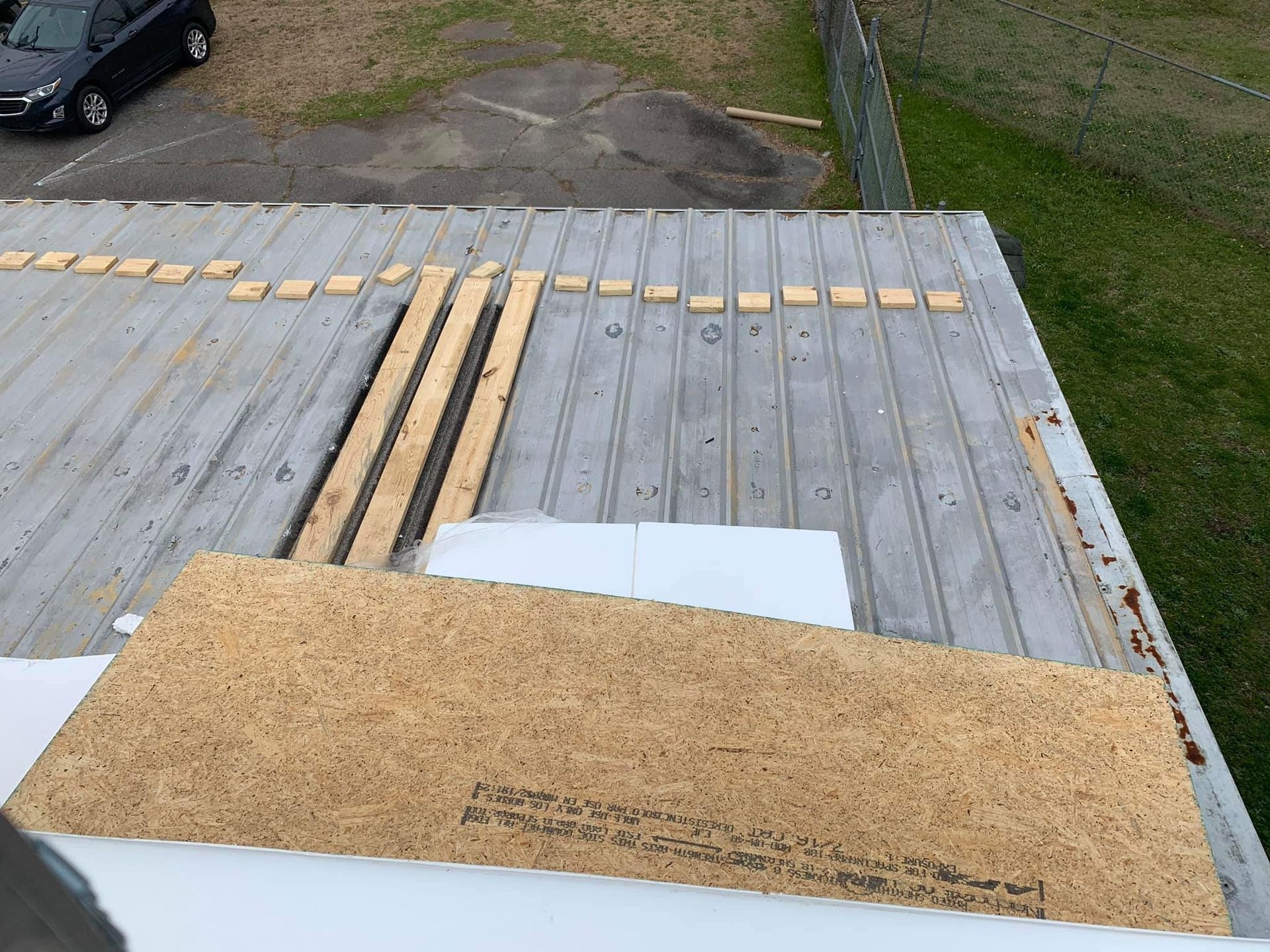 Roof with wooden boards, insulation, and metal sheeting, likely under construction.