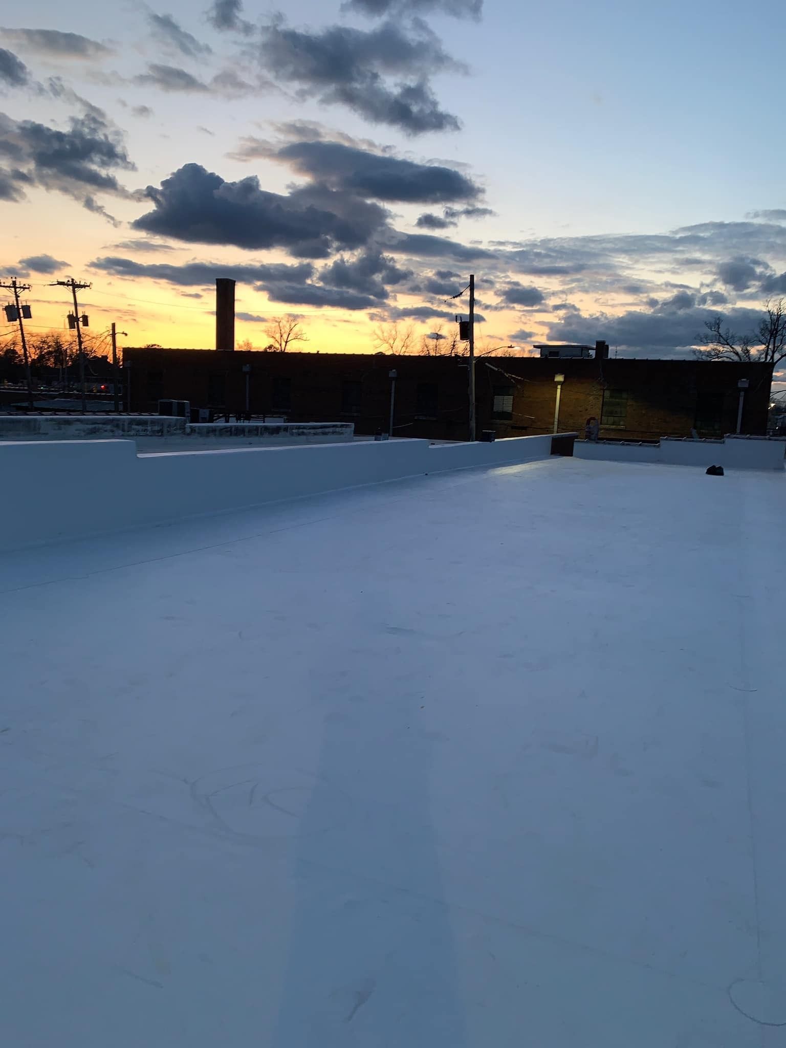 Sunset over a flat roof. A dark building silhouette against the colorful sky.
