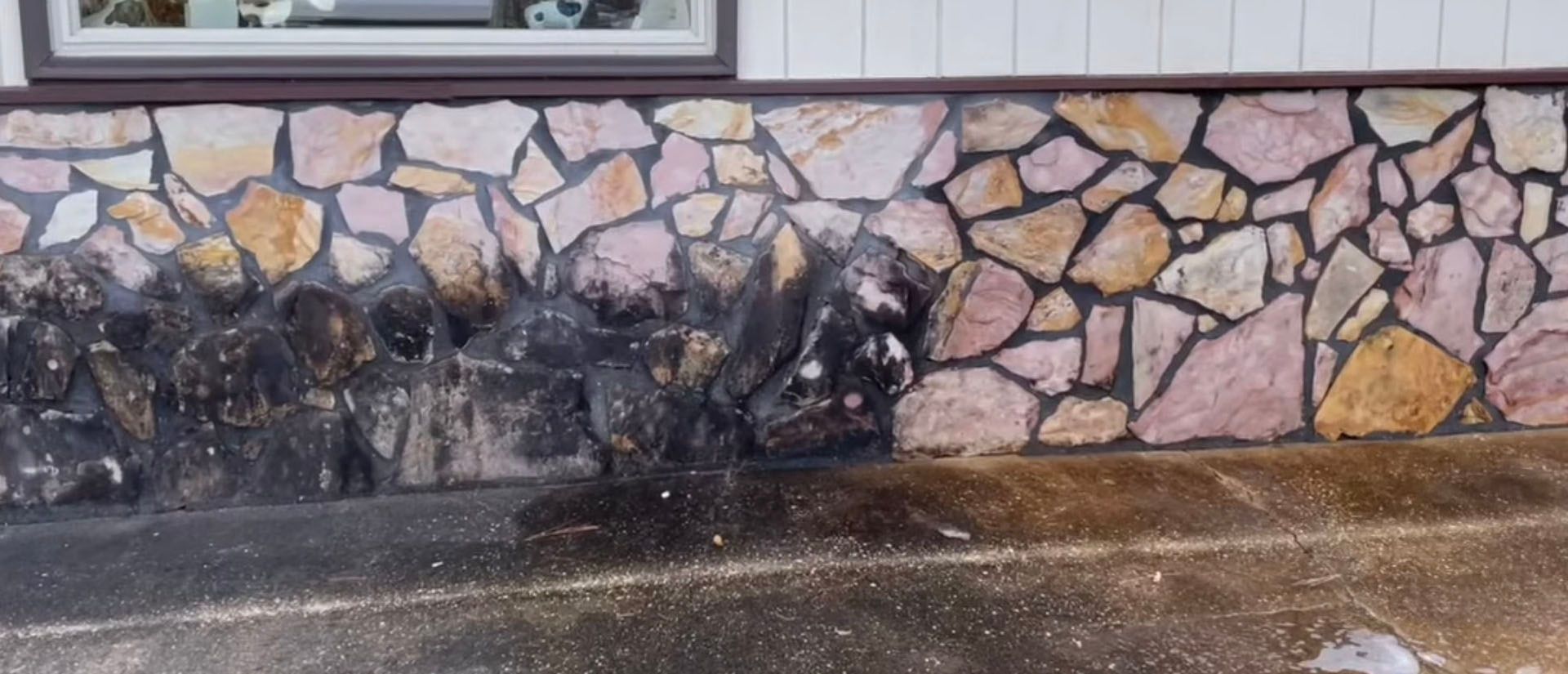 Stone wall with a dark, likely stained, section near the ground.