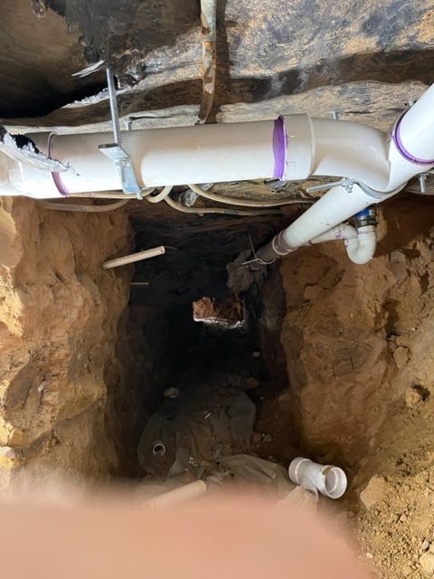 A bunch of pipes are coming out of a hole in the ground.
