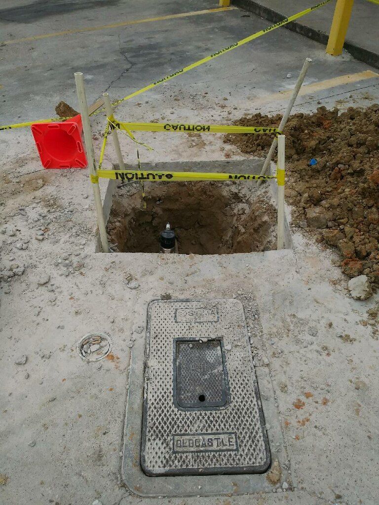 A manhole cover is sitting in the middle of a hole in the ground.