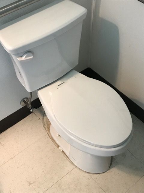 A white toilet sits on a tiled floor in a bathroom