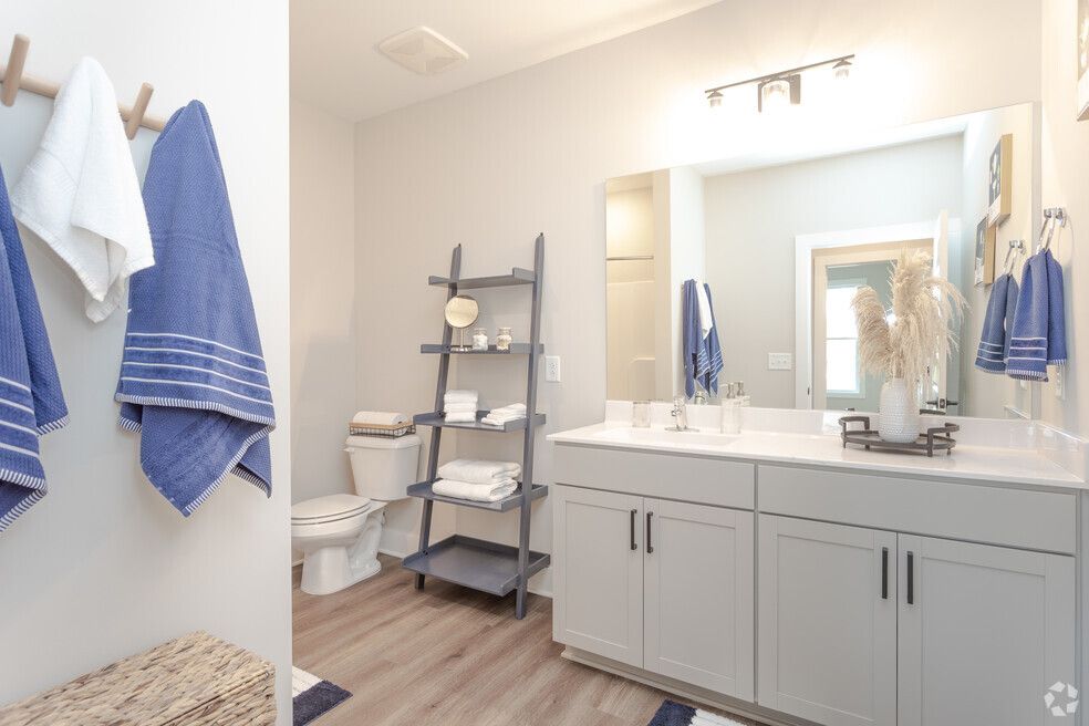 a bathroom with a toilet, sink, and mirror