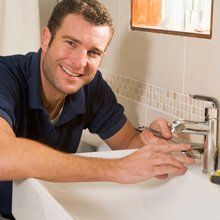 Plumber smilng while fixing the sink