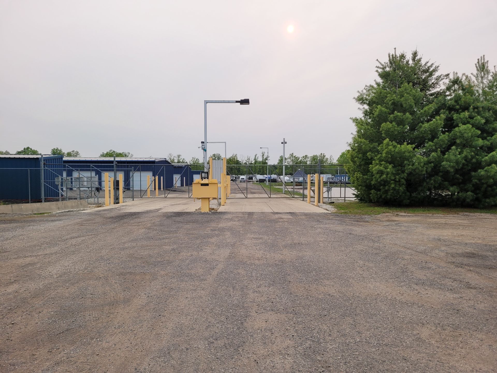 self-storage facility with metal gate and trees