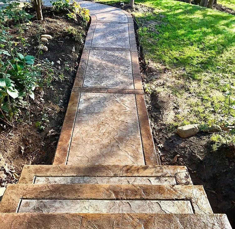 Stone walkway with steps leading up through a grassy garden path
