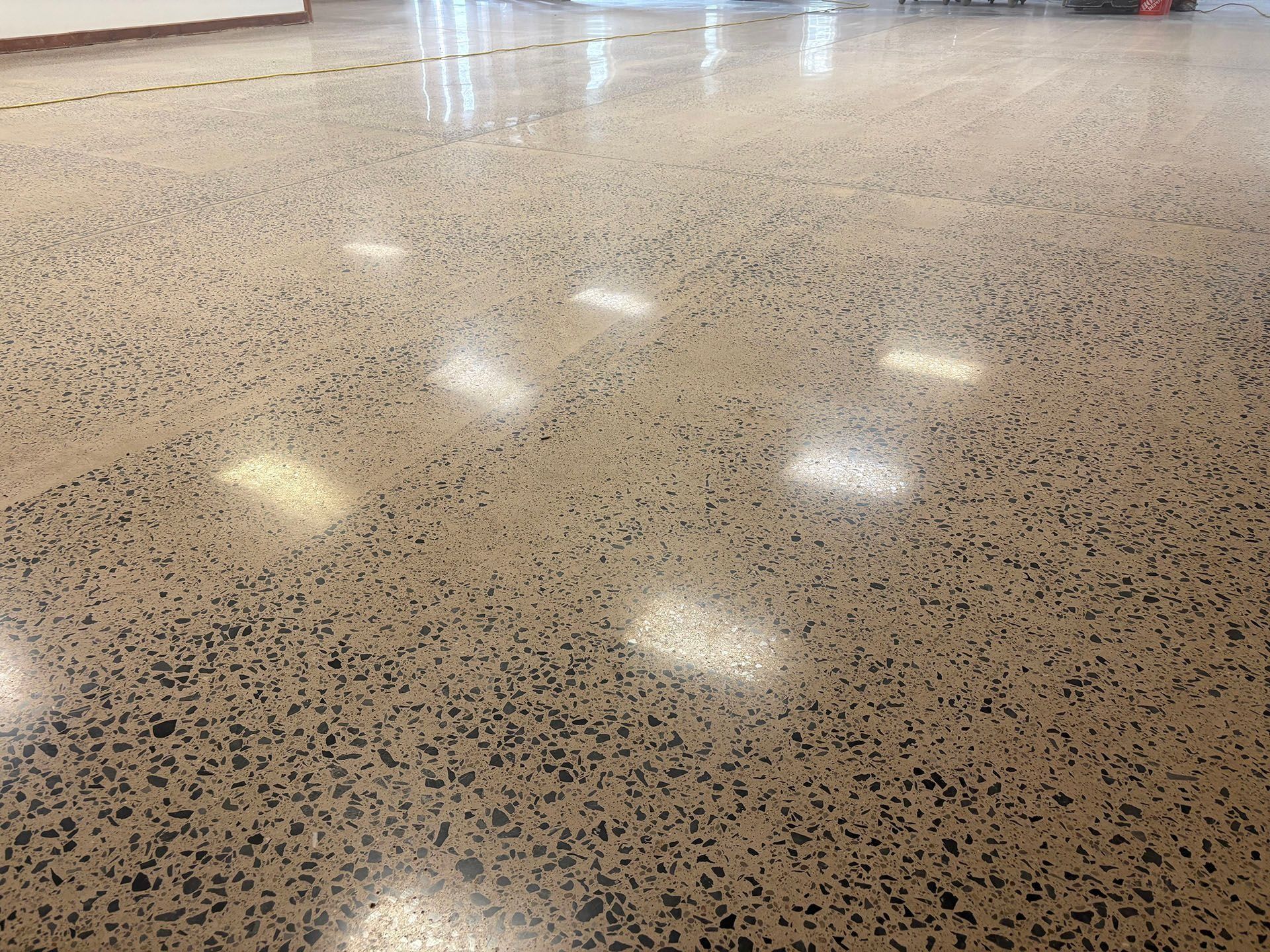 Polished concrete floor with visible aggregate, reflecting overhead lights.