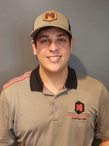 Man wearing a hat and polo shirt with a company logo, smiling.