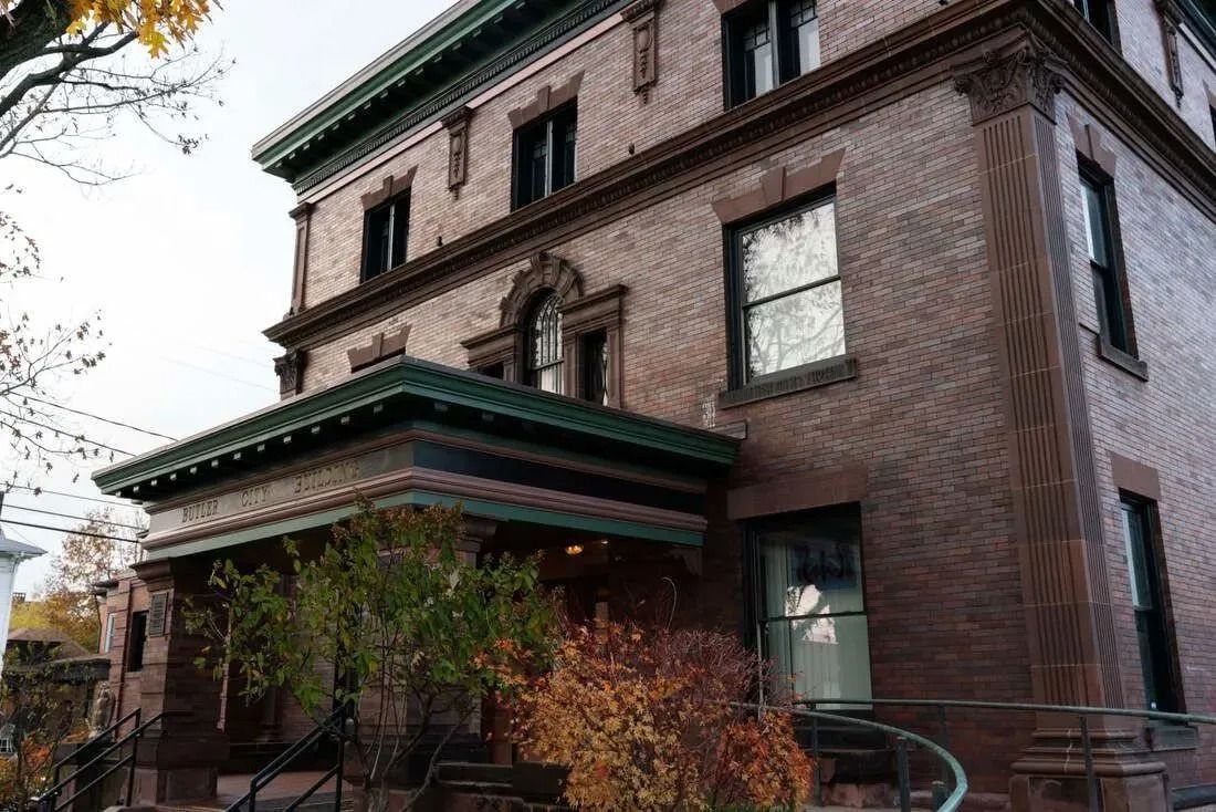 Brick house with green trim and a covered porch.