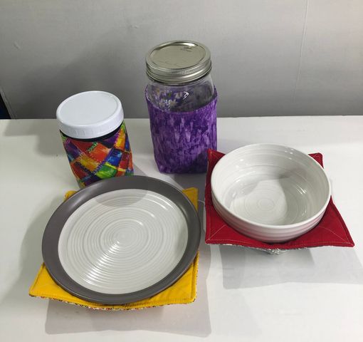 a plate a bowl and a jar are on a table