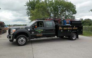 Black work truck with tool boxes; "24 Hour Crane Service Welding" displayed.