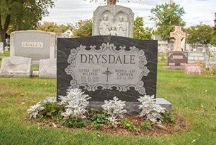 Black tombstone in a cemetery, with the name
