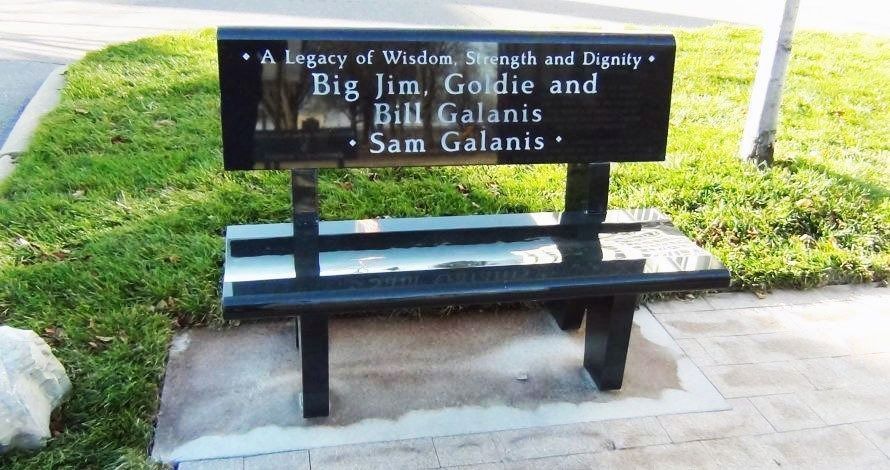 A black granite bench with inscriptions: 