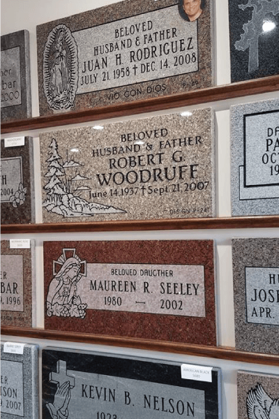 Headstones on display: Juan Rodriguez, Robert Woodruff, Maureen Seeley, and Kevin Nelson are engraved with names, dates, and epitaphs.