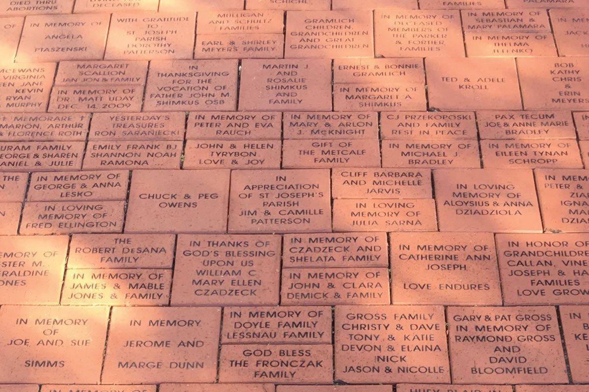 Close-up of engraved bricks, likely a memorial or walkway, with names and dedications.