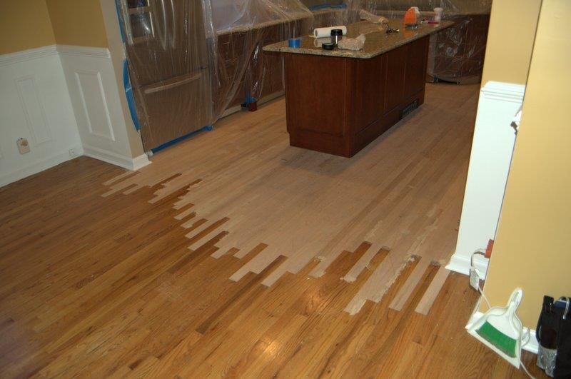 A kitchen with a wooden floor and a large island.