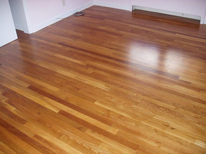 A wooden floor in a room with a pink wall