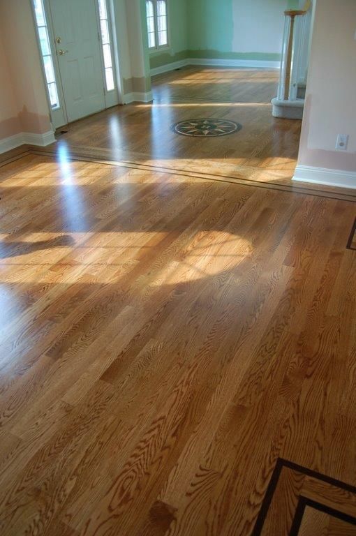 A living room with hardwood floors and a circular design on the floor.