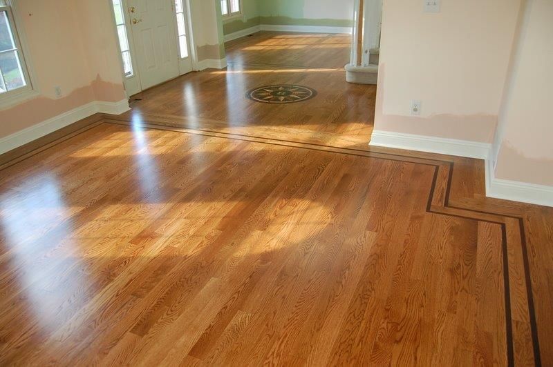A living room with hardwood floors and a doorway leading to a hallway.