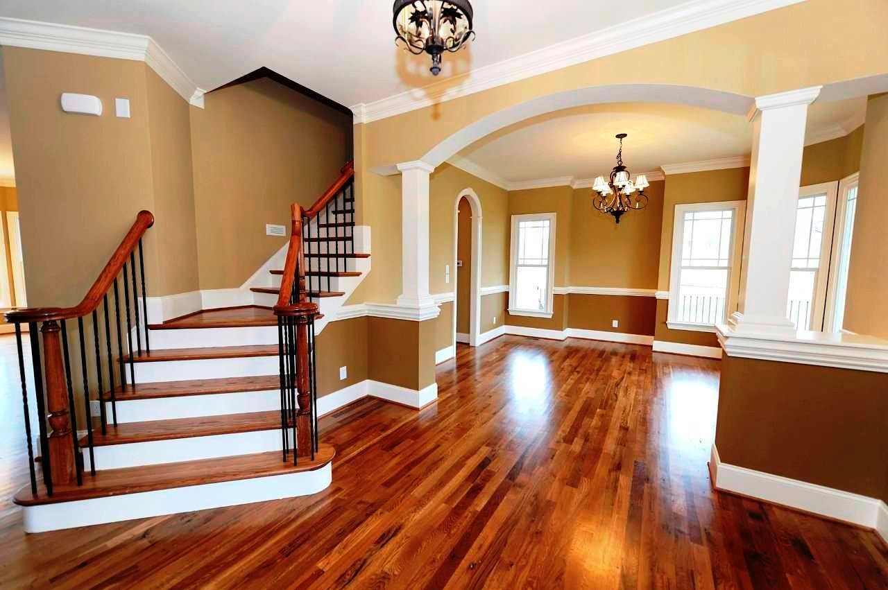 An empty house with hardwood floors and stairs