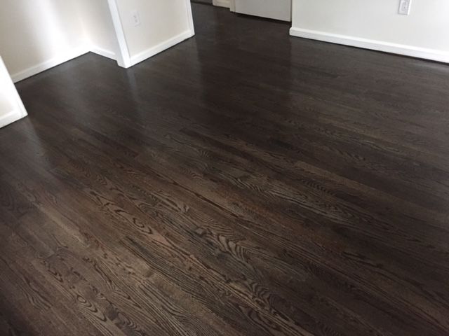 A dark wooden floor in a room with white walls.