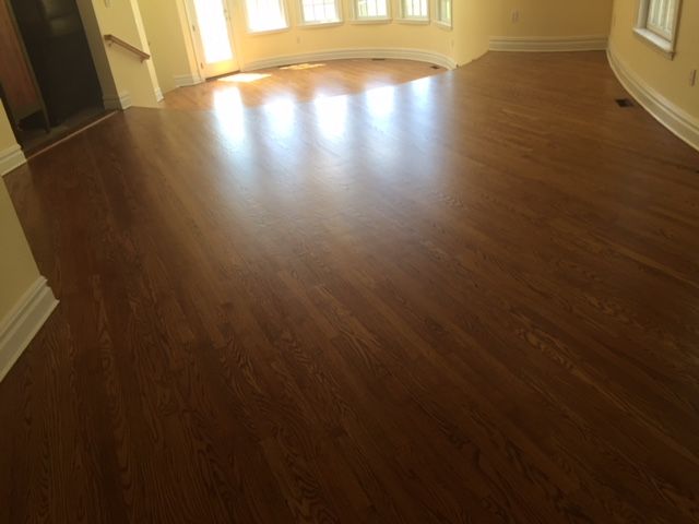 A living room with a wooden floor and white trim.