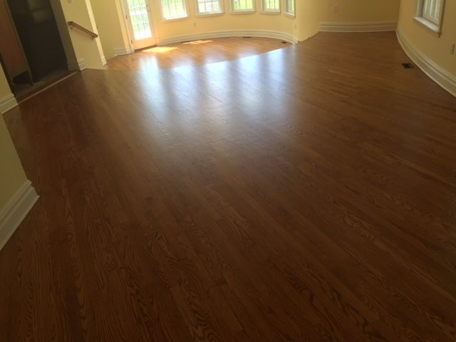 A living room with hardwood floors and a curved window.