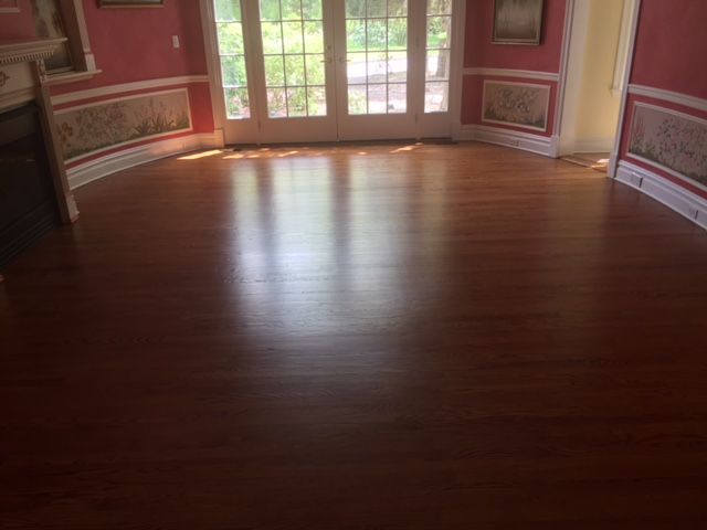 A living room with hardwood floors and pink walls.