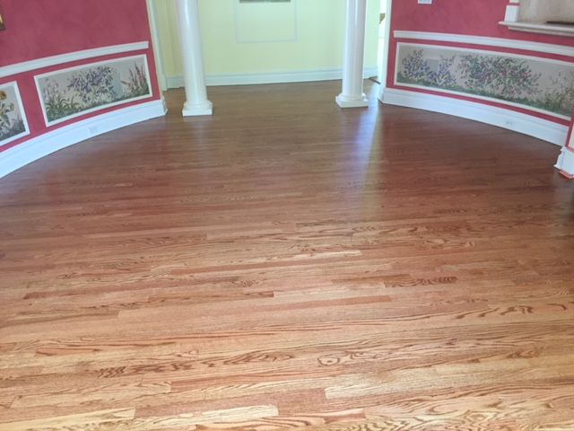 A wooden floor in a room with a curved wall.