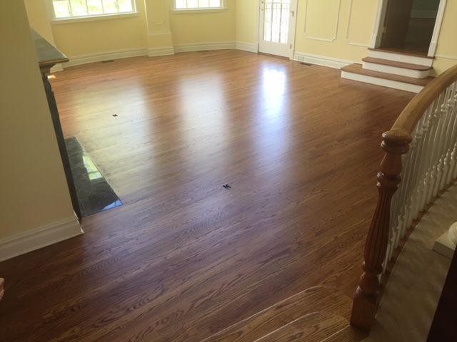 A living room with hardwood floors and stairs in a house.