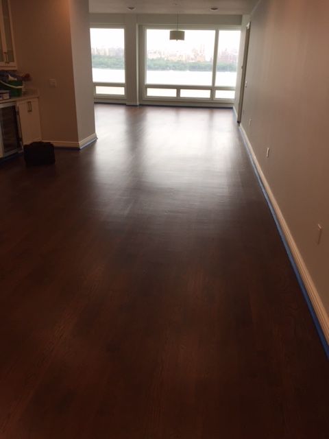 An empty room with a wooden floor and a large window