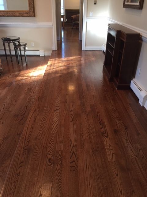 A living room with hardwood floors and a mirror