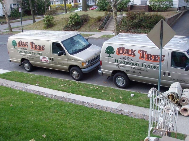 Two oak tree vans are parked on the side of the road