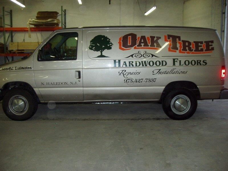A white van with oak tree hardwood floors written on it