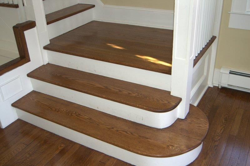 A staircase with wooden steps and white railing in a house