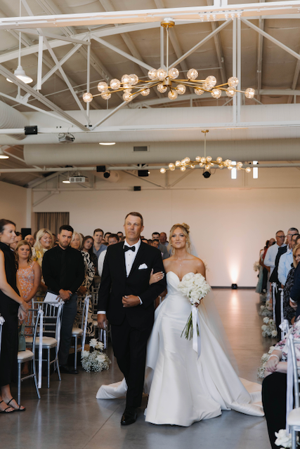 Bride and father walking down the aisle at a wedding ceremony.