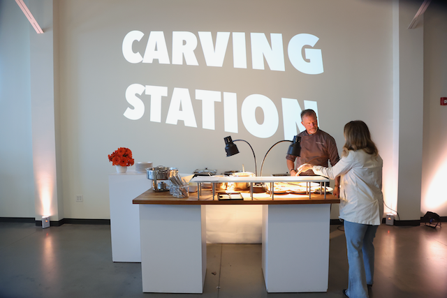 A man carving at a food station with a 