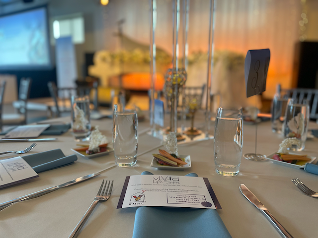 A table set for a formal event with glassware, silverware, and a menu.