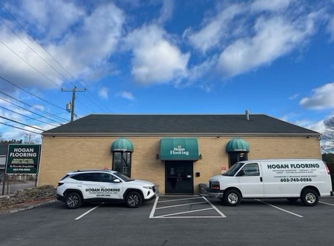 Two cars are parked in front of a building that says mosan flooring