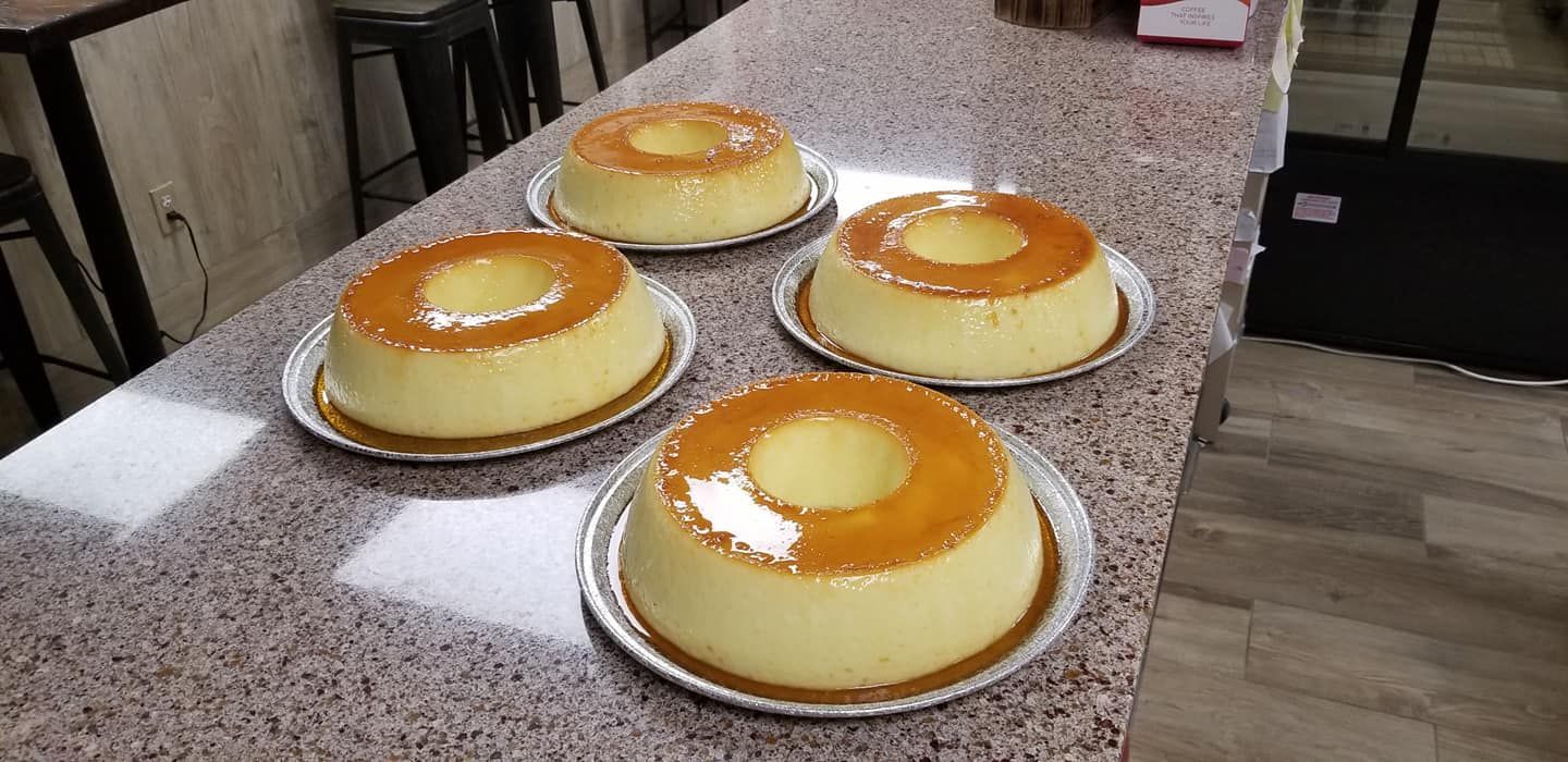 Four ring-shaped custards with glossy caramel glaze on a countertop.