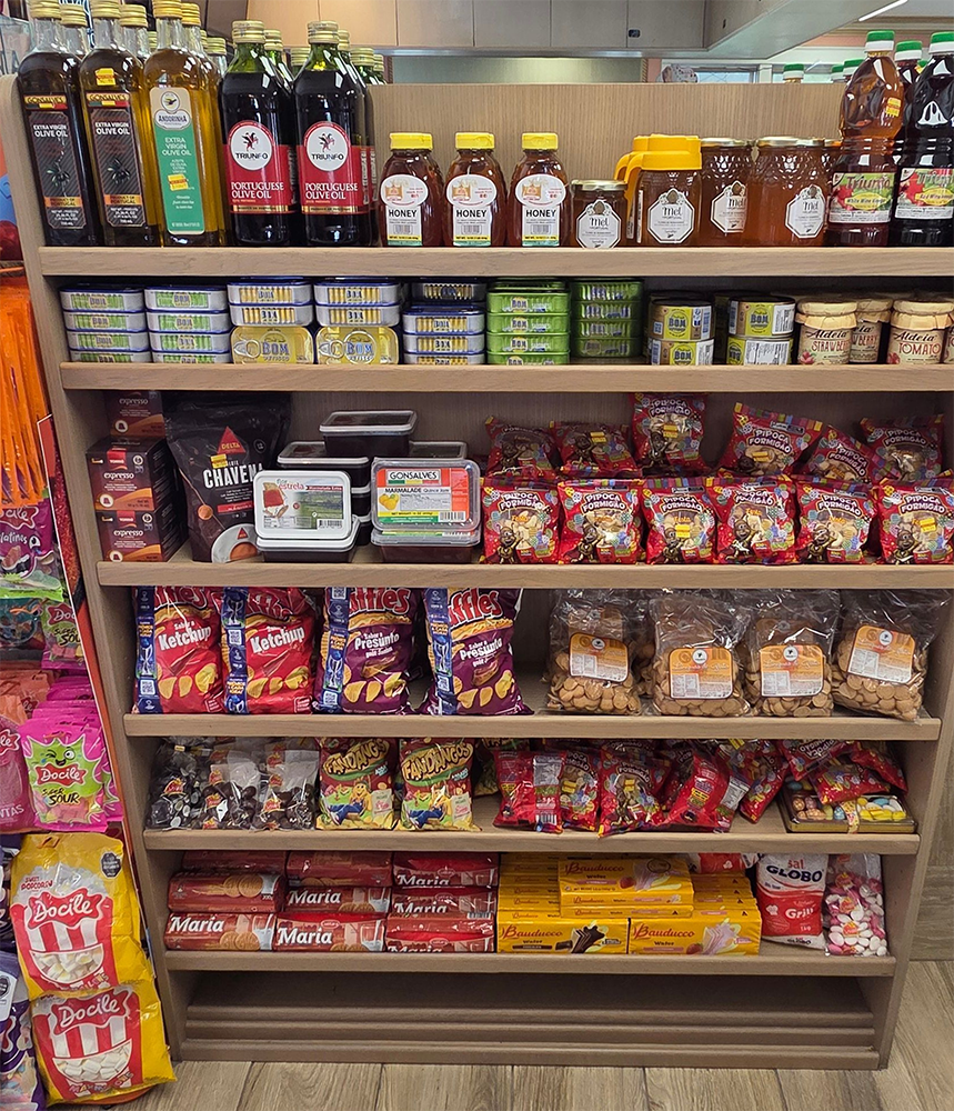Wooden shelves stocked with various food products in a market setting.