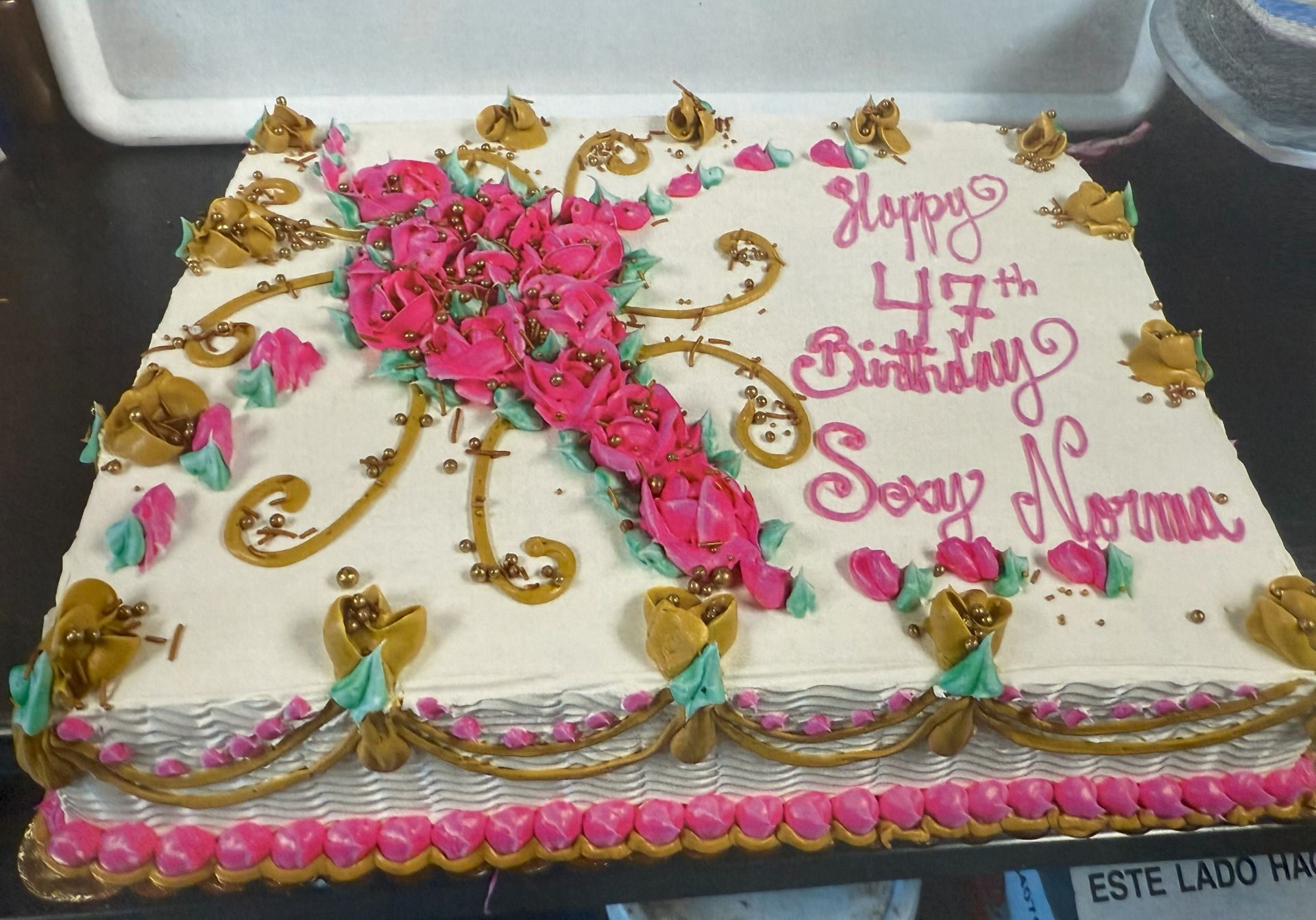 Birthday cake with pink floral design and text, 