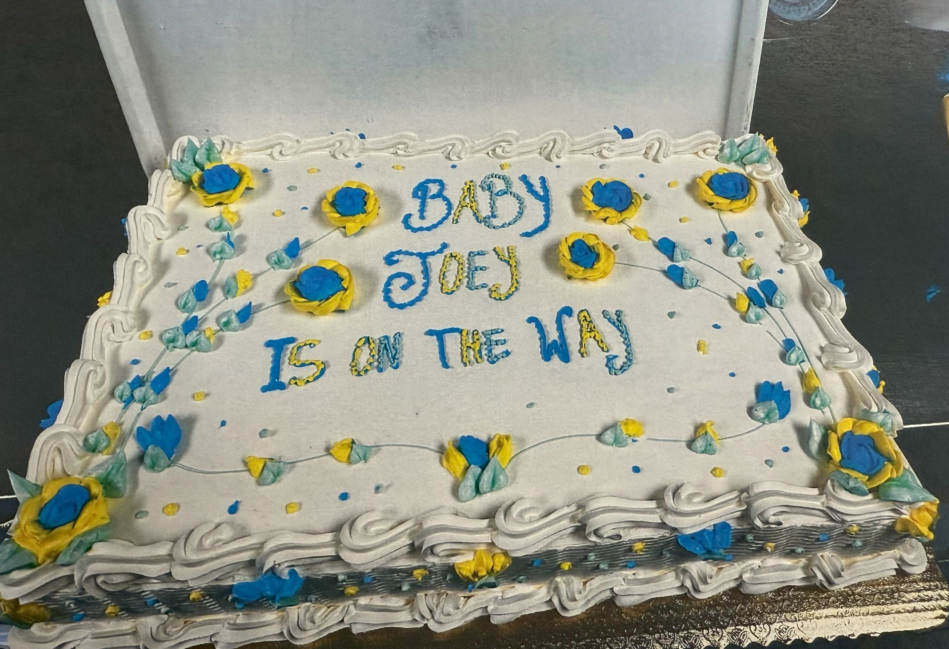 Cake decorated for baby Joey, with blue and yellow frosting, text reading 