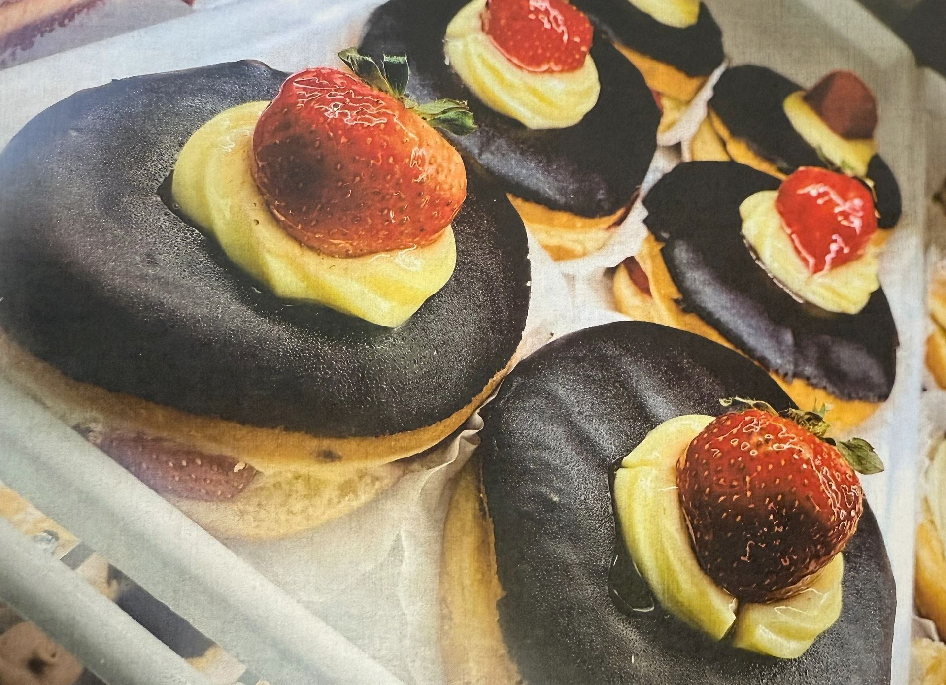 Chocolate donuts with custard and strawberries.