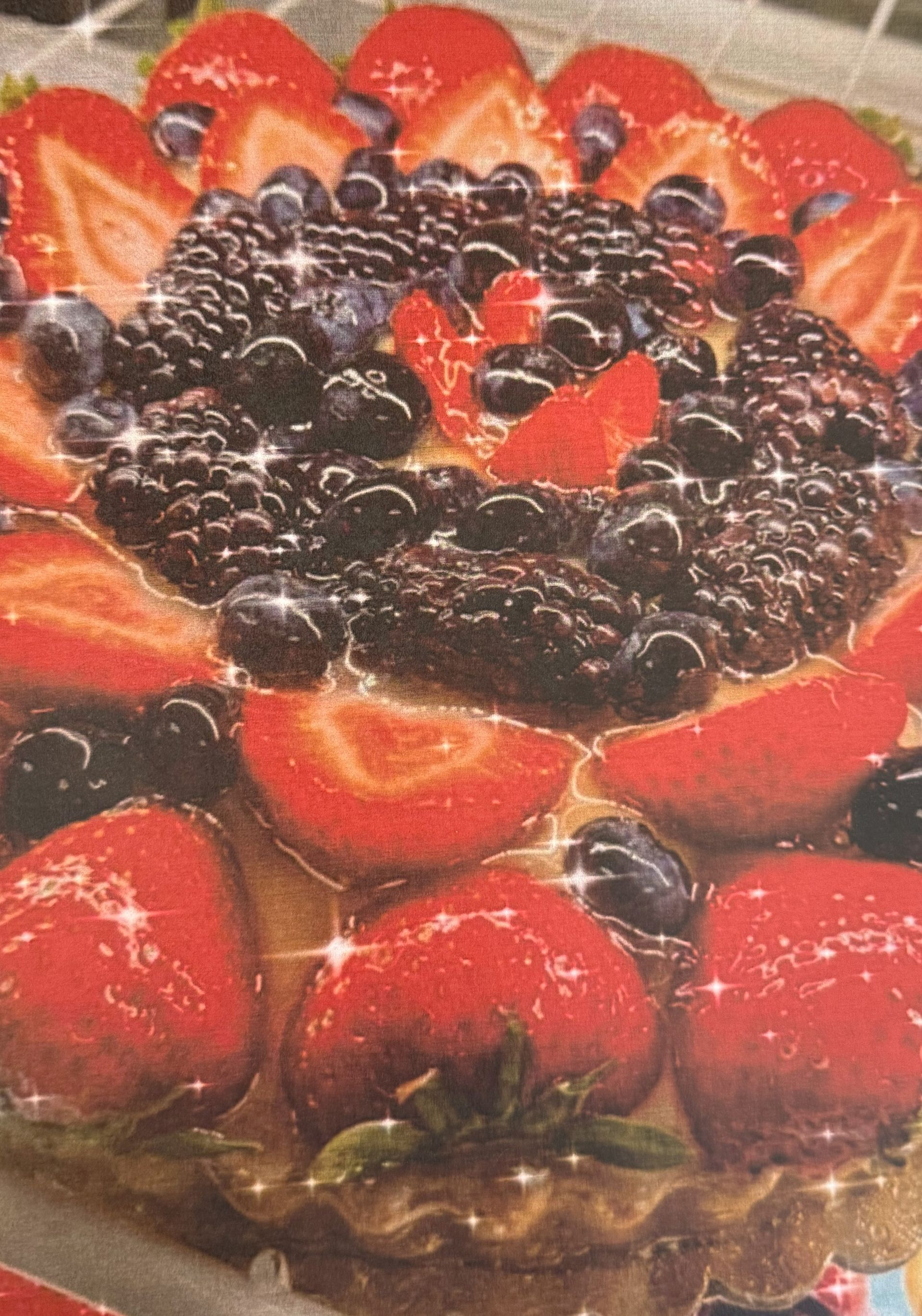 Fruit tart with strawberries, blueberries, and blackberries, glazed with a glistening coating.