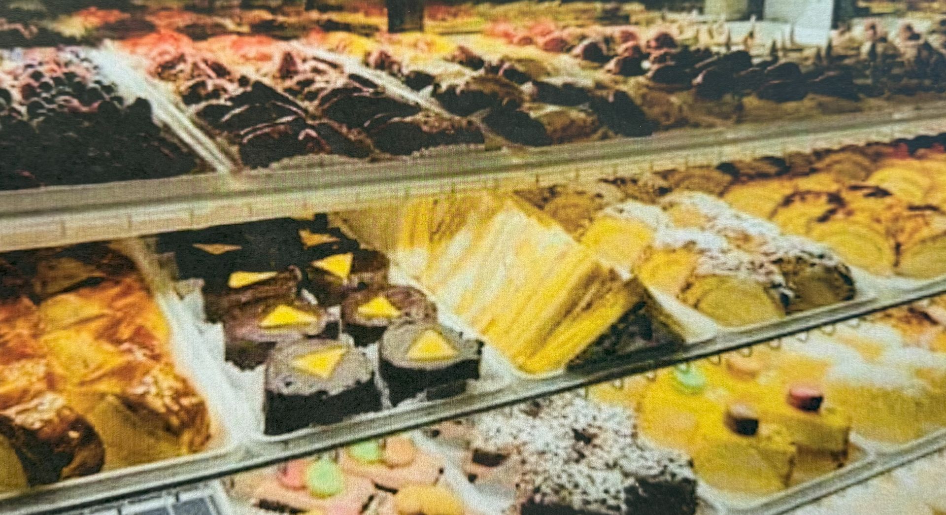 Pastries in a bakery display case, with various shapes and colors.