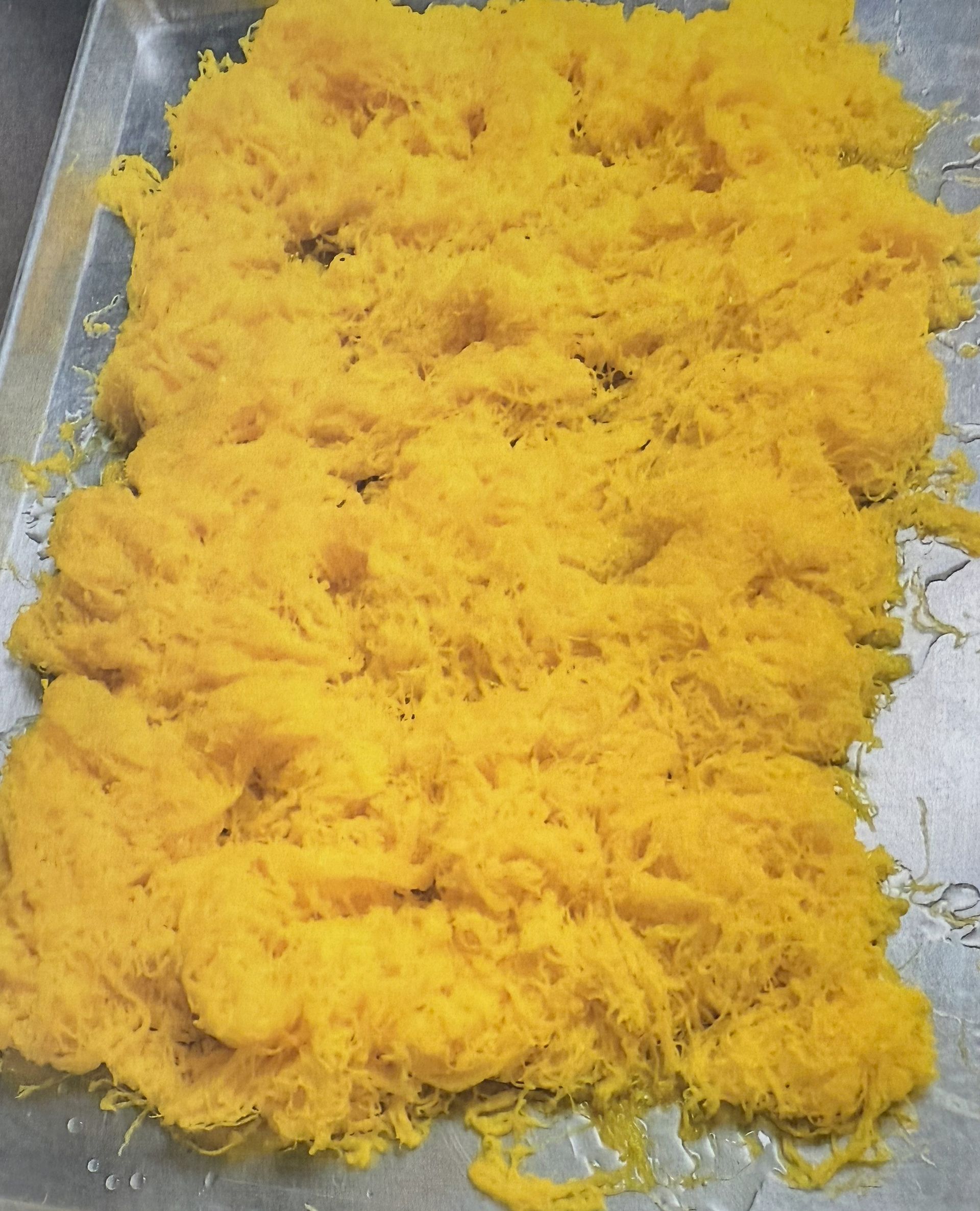 Golden yellow, shredded dessert on a silver tray.